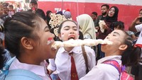 Sejumlah warga mengikuti lomba makan kerupuk di Kelurahan Ardirejo, Panji, Situbondo, Jawa Timur, Minggu (21/8/2022).   