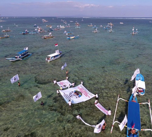 Sekeha Jukung dan Kelompok Nelayan se-Desa Adat Intaran dengan ratusan perahu menggelar aksi pawai jukung di sepanjang pesisir Sanur, Minggu (21/8/2022).