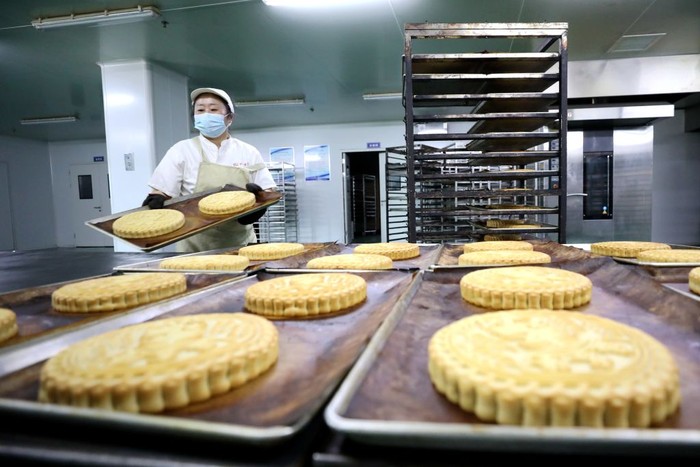 1416224763 QINGDAO, CHINA - AUGUST 21: Workers make moon cakes in preparation for the upcoming Mid-Autumn Festival on August 21, 2022 in Qingdao, Shandong Province of China. (Photo by Wang Peike/VCG via Getty Images)