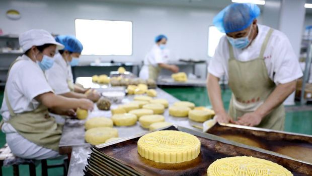 QINGDAO, CHINA - AUGUST 21: Workers make moon cakes in preparation for the upcoming Mid-Autumn Festival on August 21, 2022 in Qingdao, Shandong Province of China. (Photo by Wang Peike/VCG via Getty Images)
