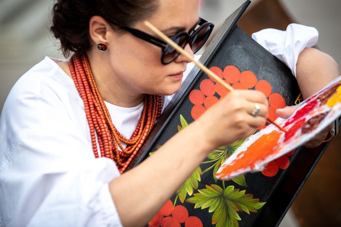 KYIV, UKRAINE - AUGUST 17: Varvara Logvyn, a master of decorative arts, paints static anti-tank devices, known as Czech hedgehogs, with Ukrainian-style Petrykivka ornament, depicting viburnum branches, which has long been a symbol of Ukraine, on Maidan Nezalezhnosti (Independence Square) on August 17, 2022 in Kyiv, Ukraine. Russia focuses its attack on the east and south of the country, but the threat of Russian missile strikes on Kyiv remains, despite Russia’s failed attempt to take the city in March. Russia launched a large-scale invasion over Ukraine on February 24, 2022, triggering the largest military attack in Europe since World War II. (Photo by Oleksii Samsonov/Global Images Ukraine via Getty Images)