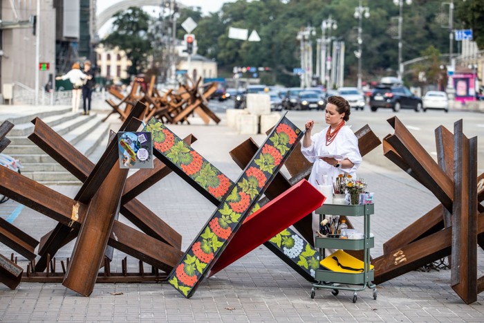 Aksi Seniman Lukis Barikade Anti-Tank di Kyiv KYIV, UKRAINE - AUGUST 17: Varvara Logvyn, a master of decorative arts, paints static anti-tank devices, known as Czech hedgehogs, with Ukrainian-style Petrykivka ornament, depicting viburnum branches, which has long been a symbol of Ukraine, on Maidan Nezalezhnosti (Independence Square) on August 17, 2022 in Kyiv, Ukraine. Russia focuses its attack on the east and south of the country, but the threat of Russian missile strikes on Kyiv remains, despite Russiaβs failed attempt to take the city in March. Russia launched a large-scale invasion over Ukraine on February 24, 2022, triggering the largest military attack in Europe since World War II. (Photo by Oleksii Samsonov/Global Images Ukraine via Getty Images)