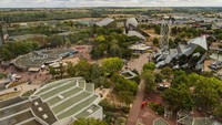 Foto dari atas menunjukkan taman hiburan Futuroscope dengan bangunan futuristik dan beragam wahana permainan.