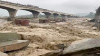 Arus air sangat kuat membuat jembatan roboh. Hujan deras ini menyebabkan Sungai Chakki di Kangra, Himachal Pradesh, meluap.  (ANI/Reuters)