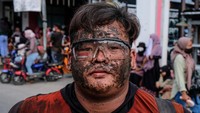 Salah satu siswa ini yang melumurkan bubuk hitam ke seluruh wajahnya untuk mengikuti acara karnaval tersebut.