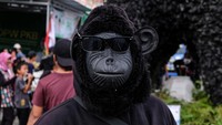 Siswa ini memakai topeng mirip orang hutan dilengkapi dengan kaca mata hitam.