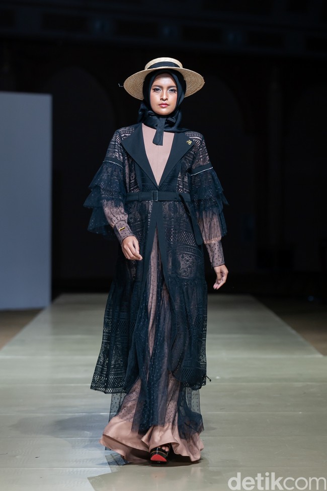 Brand Muslim Wear Deluxe by Khansa Maaziah Ramdhani menhadirkan busana muslim yan dirancang untuk para hijabers muda hingga dewasa di Jogja Fashion Week 2022. Konsep fashion Muslim Wear Deuxe kali ini, terinspirasi dari salah satu wisata budaya di Jawa Tengah, Candi Borobudur. Dalam koleksi ini digunakan batik dan lurik sebagai ciri khas Jawa Tengah. Terdapat juga siluet setelan kebaya modern, long coat, blouse, skirt, dan pants, dengan aksen draperi dan payet. Foto: Ajiwara Photography.