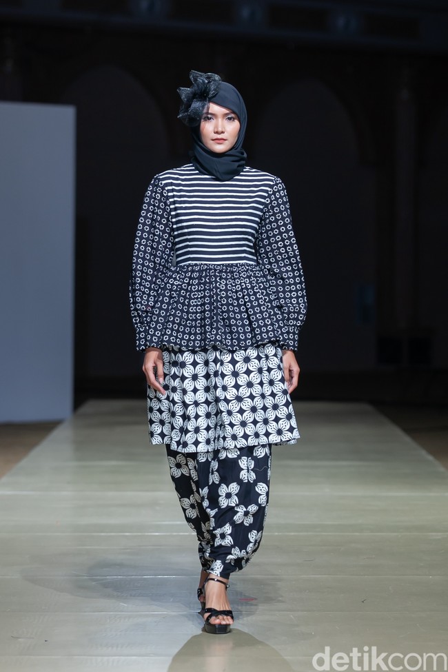Berikutnya ada Mazyaa by Umi Istia’anah yang berasal dari Pekanbaru, Riau. Tampil di Jogja Fashion Week, brand lokal ini berkolaborasi dengan brand hijab dari Purworejo, Jawa Tengah, yaitu Manisa. Menampilkan karyanya yang bertema Metamorfosa, Manisa x Mazyaa menggunakan warna dasar hitam dan putih. Warna hitam mempunyai arti yang melambangkan keanggunan, kemakmuran dan kecanggihan, juga merupakan warna yang independen dan penuh misteri. Sedangkan warna putih mempunyai arti kesucian, kemurnian, kepolosan dan kelengkapan sehingga dalam ilmu psikologi warna, putih merupakan simbol dari awal yang baru. Foto: Ajiwara Photography.