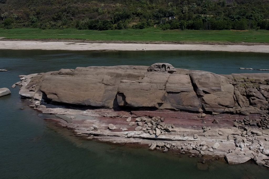 Patung Buddha yang pernah tenggelam bersandar di bebatuan Pulau Foeliang di Sungai Yangtze, yang muncul setelah permukaan air turun karena kekeringan regional di Chongqing, China, pada 20 Agustus 2022.  Gambar hari ini oleh REUTERS/Thomas Peter TPX