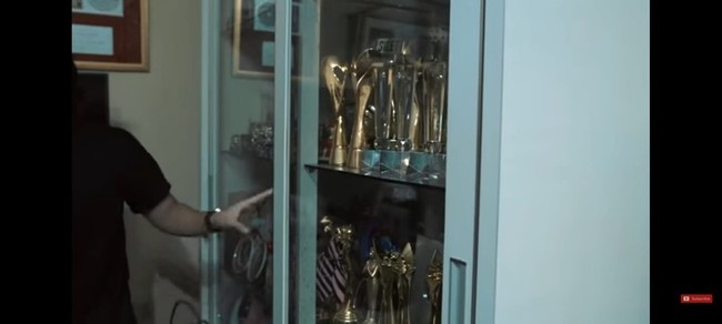Tak hanya itu, di ruang keluarga Ayu juga ada lemari kaca yang isinya piala-piala atas pencapaian kerja keras Ayu selama ini. (Foto: YouTube/AH)