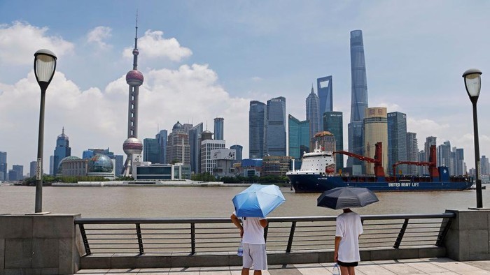 1241857810 People walk on The Bund in the Huangpu district of Shanghai on July 12, 2022. (Photo by Hector RETAMAL / AFP) (Photo by HECTOR RETAMAL/AFP via Getty Images)