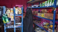 Istri Samsul memeriksa barang dagangannya di toko kelontongnya. Samsul mengatakan jika ingin mengakses layanan perbankan masyarakat di Desa Batu Belah biasanya pergi ke ibu kota kabupaten, yakni Tarempa. Untuk menuju ke sana, warga harus membayar ongkos kapal hingga Rp 100 ribu untuk tarif pulang-pergi.  