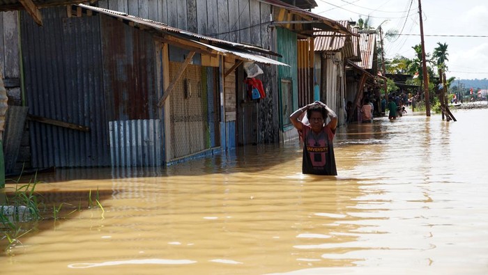 BANJIR KEPUNG KOTA SORONG Warga berjalan menerobos banjir untuk mengungsi di kompleks Kokoda Kota Sorong, Papua Barat, Selasa (23/8/2022). BPBD Kota Sorong menyebutkan bencana banjir dan tanah longsor yang terjadi sejak Selasa (23/8) dini hari di wilayah tersebut mengakibatkan dua orang meninggal dunia, satu orang luka berat dan 9.000 KK mengungsi. ANTARA FOTO/Olha Mulalinda/rwa.