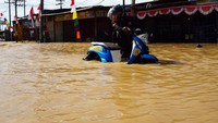 Pengendara sepeda motor menerobos banjir di Jalan Basuki Rahmat Kota Sorong, Papua Barat, Selasa (23/8/2022).