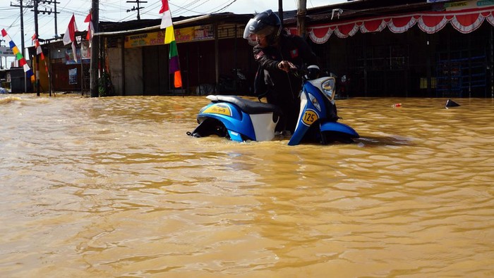 Warga berjalan menerobos banjir untuk mengungsi di kompleks Kokoda Kota Sorong, Papua Barat, Selasa (23/8/2022). BPBD Kota Sorong menyebutkan bencana banjir dan tanah longsor yang terjadi sejak Selasa (23/8) dini hari di wilayah tersebut mengakibatkan dua orang meninggal dunia, satu orang luka berat dan 9.000 KK mengungsi. ANTARA FOTO/Olha Mulalinda/rwa.