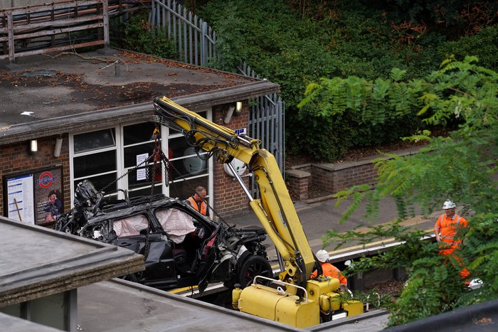 BRITAIN-CRASH/ Rescuers work at the crash site where a Range Rover veered off the road onto the Piccadilly Line train track after colliding with Tesla, at Park Royal Station in West London, Britain August 22, 2022. REUTERS/Maja Smiejkowska