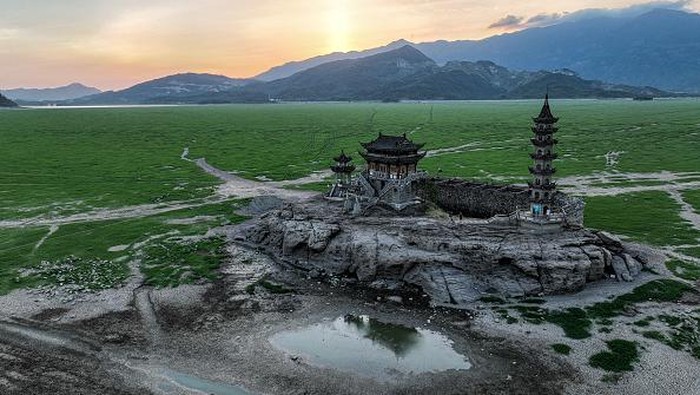 Dulu Pagoda Ini Ada di Tengah Danau China, Kini Dihampar Kekeringan JIUJIANG, CHINA - AUGUST 22: Aerial view of the historic site of Luoxingdun Island standing on the dried lake bed of Poyang Lake on August 22, 2022 in Jiujiang, Jiangxi Province of China. Poyang Lake has entered the dry season, the earliest date in 71 years on Friday as a result of persistent high temperatures. (Photo by Li Jie/VCG via Getty Images)