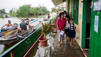 Meski sekolah terendam banjir, para orangtua tetap semangat mengantarkan anaknya untuk sekolah tatap muka setelah 2 tahun lockdown.