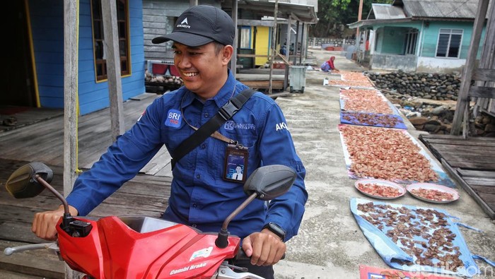 Widayanti (47) keluar dari rumahnya di Desa Keramut, Kabupaten Kepulauan Anambas, Kepulauan Riau, Kamis (4/8/2022).