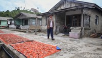 Widayanti (47) keluar dari rumahnya di Desa Keramut, Kabupaten Kepulauan Anambas, Kepulauan Riau, Kamis (4/8/2022).