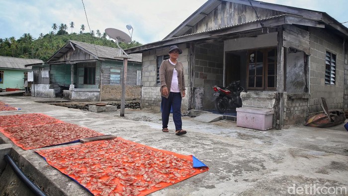 Widayanti (47) keluar dari rumahnya di Desa Keramut, Kabupaten Kepulauan Anambas, Kepulauan Riau, Kamis (4/8/2022).