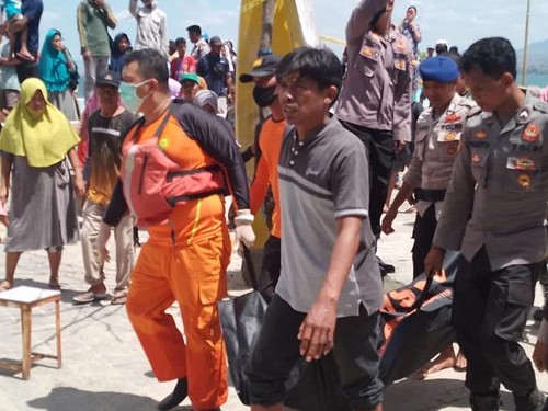 Pihak kepolisian dibantu warga saat mengevakuasi jasad yang ditemukan mengapung di pantai Lawata, Kota Bima