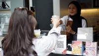 Seorang pengunjung asyik memesan kopi untuk dinikmati di alam terbuka. Yakin nih, Travelers nggak tertarik untuk ikut kongkow cantik sambil ngopi-ngopi di alam terbuka. 