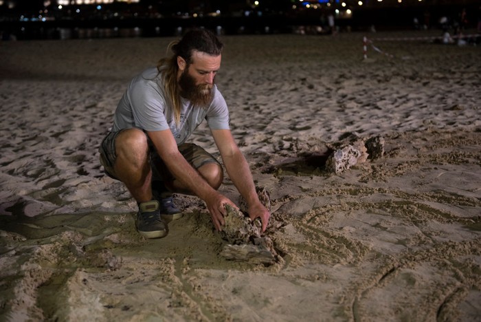 SAN SEBASTIAN, SPAIN - AUGUST 22: Land Art artists Jon Foreman (L) and James Brunt (R) look at five meter diameter symbol of the House Targaryen they created using stones on La Concha beach to promote the 