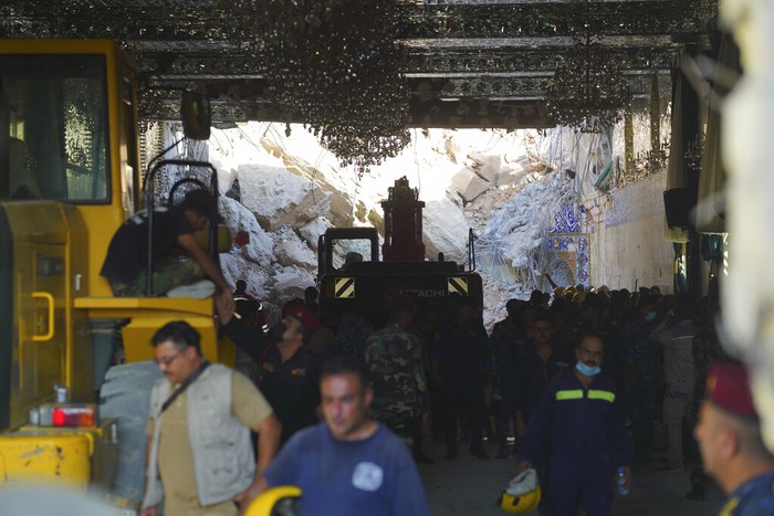 Tanah longsor menimpa kuil Qattarat al-Imam Ali. Emergency services and rescue workers are seen at Qattarat al-Imam Ali shrine near Karbala, Iraq, Sunday, Aug. 21, 2022. Several people died and others were trapped under the rubble after a mound collapsed onto the shrine. (AP Photo/Anmar Khalil)