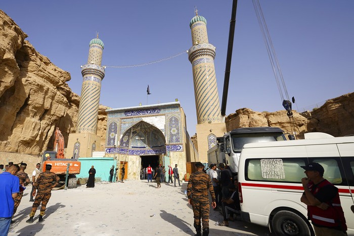 Tanah longsor menimpa kuil Qattarat al-Imam Ali. Emergency services and rescue workers are seen at Qattarat al-Imam Ali shrine near Karbala, Iraq, Sunday, Aug. 21, 2022. Several people died and others were trapped under the rubble after a mound collapsed onto the shrine. (AP Photo/Anmar Khalil)