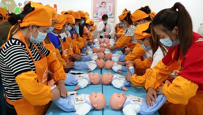 Tengok Cara Wanita di China Berlatih Rawat Bayi QIANDONGNAN, CHINA - AUGUST 22: Rural women learn baby care skills at a training center of Rongjiang County on August 22, 2022 in Qiandongnan Miao and Dong Autonomous Prefecture, Guizhou Province of China. (Photo by Li Changhua/VCG via Getty Images)