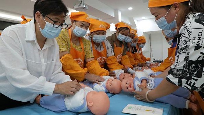 Tengok Cara Wanita di China Berlatih Rawat Bayi QIANDONGNAN, CHINA - AUGUST 22: Rural women learn baby care skills at a training center of Rongjiang County on August 22, 2022 in Qiandongnan Miao and Dong Autonomous Prefecture, Guizhou Province of China. (Photo by Li Changhua/VCG via Getty Images)