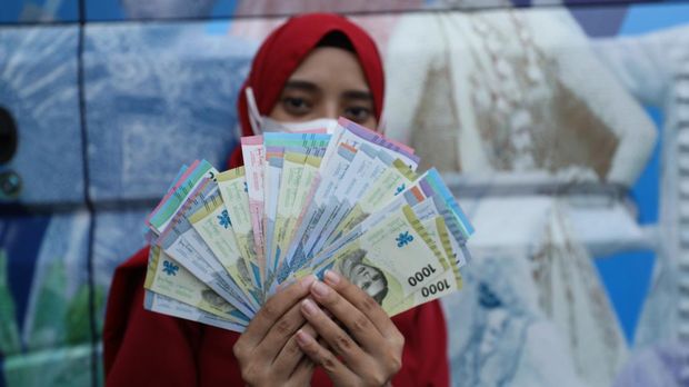 Warga antre untuk menukarkan uang baru tahun emisi 2022 di Pasar Slipi, Jakarta, Selasa (23/8/2022). (CNBC Indonesia/Tri Susilo)