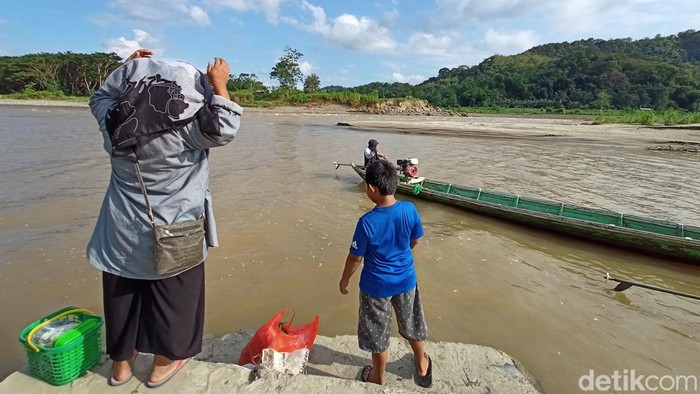 Warga Sudda Kecamatan Enrekang, saat hendak menaiki sampan akibat belum adanya fasilitas jembatan.