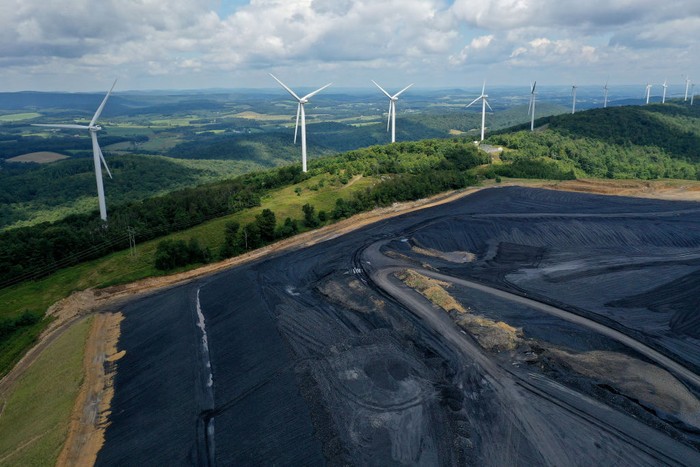 1417457299 OAKLAND, MARYLAND - AUGUST 23: In an aerial view, turbines from the Roth Rock wind farm spin on the spine of Backbone Mountain next to the Mettiki Coal processing plant on August 23, 2022 in Oakland, Maryland. The 50,000 kilowatt Roth Rock project has 20 Nordex N90/2500 turbines and has been operating since 2011. Once Maryland’s largest coal mine, the Mettiki pulled a total of 55 million short tons from the Upper Freeport seam in Garrett County’s southwestern corner between 1983 and 2006, when the mine was closed. Today, the former mine site still washes, separates and processes coal from nearby mines. (Photo by Chip Somodevilla/Getty Images)