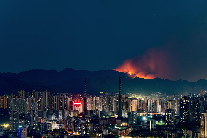 CHONGQING, CHINA - AUGUST 23: Smoke and flames rise from a mountain during a wildfire in Banan district on August 23, 2022 in Chongqing, China. The wildfire that broke out last Sunday afternoon has been brought under control by firefighters in Chongqing. (Photo by VCG/VCG via Getty Images)