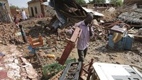 Seorang pria menyelamatkan barang-barang miliknya yang masih bisa disimpan.