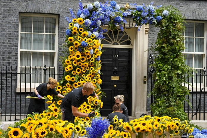 Florists prepare the entrance to 10 Downing Street with flowers in the Ukraine national colours in London, Tuesday, Aug. 23, 2022 a day ahead of the Independence Day of Ukraine. (AP Photo/Frank Augstein)
