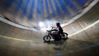 Para joki mencoba terlihat keren di atas motornya yang bergerak cepat saat beratraksi dalam sebuah kandang atau tong raksasa.