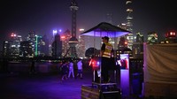 Orang-orang mengunjungi The Bund yang dimatikan aliran listriknya, di Shanghai, China, Senin (22/6/2022).