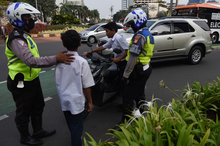 HUKUMAN TILANG MENYANYIKAN LAGU INDONESIA RAYA Dua pelajar SMP terjaring razia di kawasan Bundaran HI, Jakarta, Selasa (23/8/2022). Polisi memberikan hukuman tilang berupa menyanyikan lagu Indonesia Raya kepada kedua pelajar tersebut karena tidak memiliki SIM dan membawa STNK serta tidak mengenakan helm saat berkendara. ANTARA FOTO/Indrianto Eko Suwarso/hp.