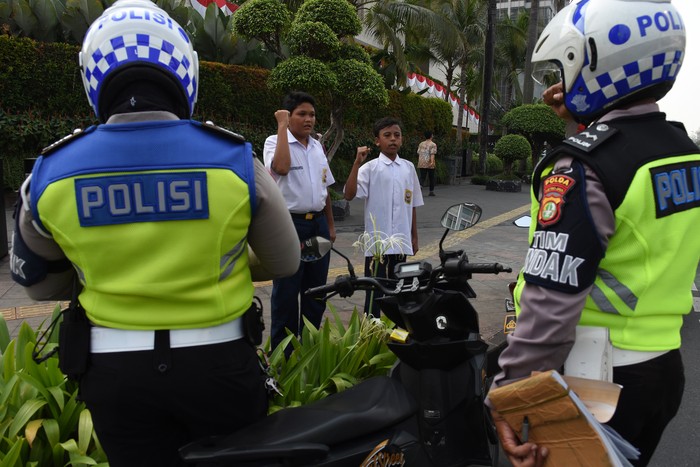 HUKUMAN TILANG MENYANYIKAN LAGU INDONESIA RAYA Dua pelajar SMP terjaring razia di kawasan Bundaran HI, Jakarta, Selasa (23/8/2022). Polisi memberikan hukuman tilang berupa menyanyikan lagu Indonesia Raya kepada kedua pelajar tersebut karena tidak memiliki SIM dan membawa STNK serta tidak mengenakan helm saat berkendara. ANTARA FOTO/Indrianto Eko Suwarso/hp.