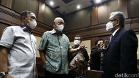 Para penasehat hukum berdiskusi terkait penundaan ini. Seharusnya sidang pembacaan dakwaan akan digelar di ruang Muhammad Hatta Ali, Pengadilan Tipikor pada PN Jakarta Pusat, mulai pukul 10.00 WIB.