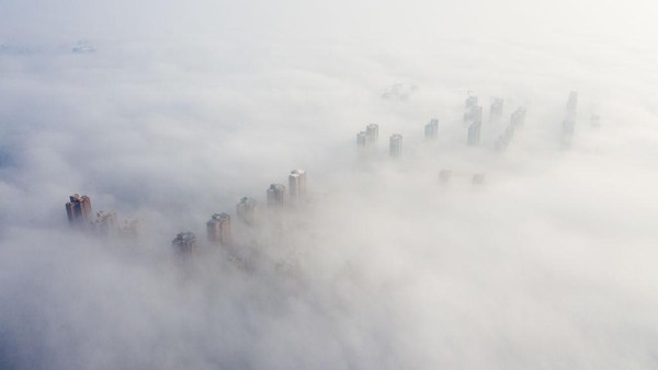 Lanjut, deretan gedung pencakar langit di Anhui, China, terlihat berselimutkan kabut pada 12 Februari 2020. Panorama ini sangat indah bak negeri di atas awan.