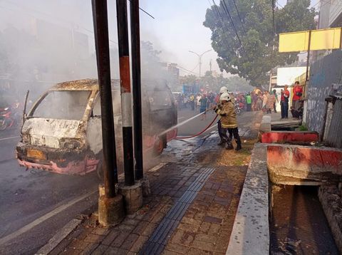 Petugas melakukan pemadaman mobil angkot yang terbakar di dekat Pasar Karangayu Semarang, Rabu (24/8/2022) pagi.