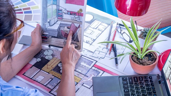Female architect working at home.She looking at blueprint.