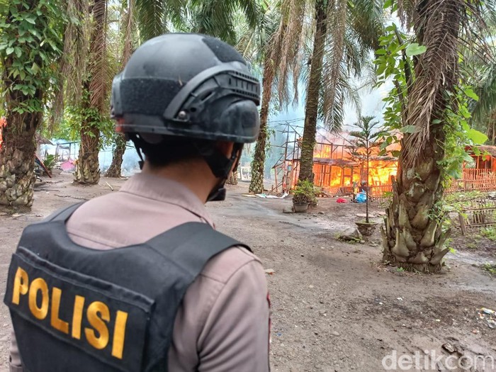Polisi menyaksikan lapak narkoba dan judi yang viral dengan sebutan Sambo Sumut dirobohkan lalu dibakar. (Goklas/detikSumut)