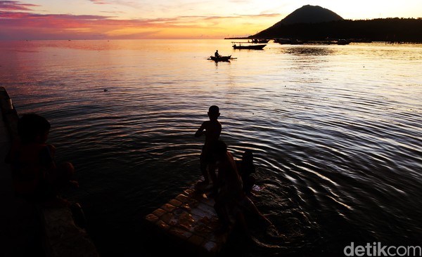 Anak-anak di pinggir dermaga melompat ke dalam laut. Riuh rendah, tawa merebak ke udara. (Bonauli/detikcom) Anak-anak di pinggir dermaga melompat ke dalam laut. Riuh rendah, tawa merebak ke udara. (Bonauli/detikcom)