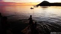Anak-anak di pinggir dermaga melompat ke dalam laut. Riuh rendah, tawa merebak ke udara.  (Bonauli/detikcom)