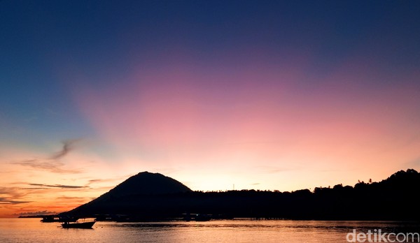 Ungu dengan rona merah muda, langit Bunaken cantik tiada dua. Garis merah muda makin tajam dengan latar langit biru. (Bonauli/detikcom) Ungu dengan rona merah muda, langit Bunaken cantik tiada dua. Garis merah muda makin tajam dengan latar langit biru. (Bonauli/detikcom)